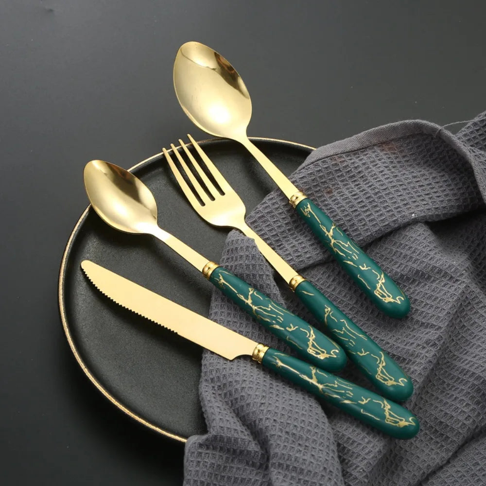 Stainless steel flatware set by MC THE BLACK DIAMOND, including forks, knives, and spoons arranged on a table.