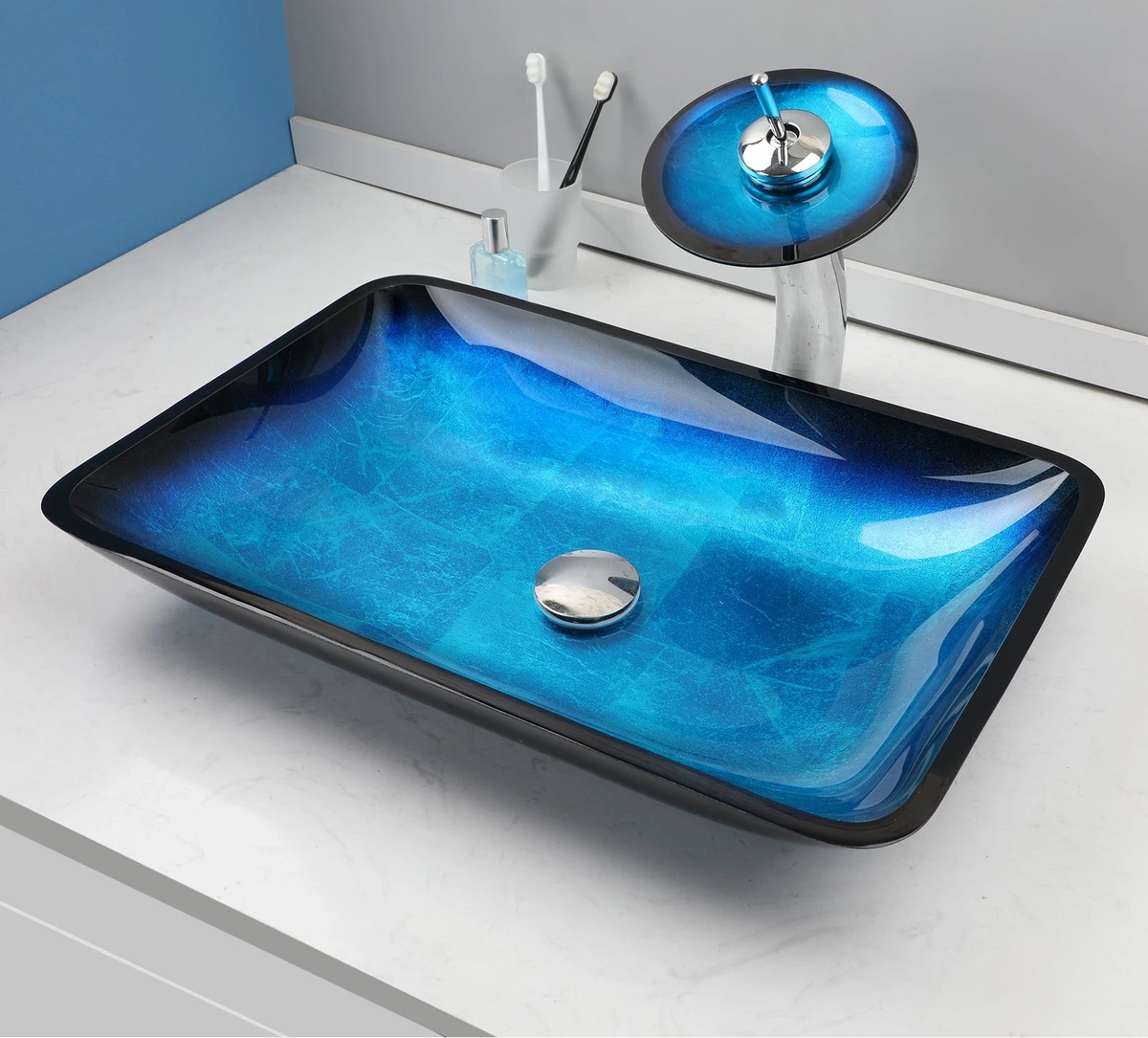 Blue glass vessel sink with waterfall faucet from MC THE BLACK DIAMOND, showcasing a modern bathroom basin and sleek water feature.
