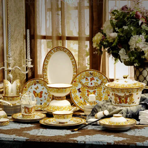 Golden butterfly dinnerware set by MC THE BLACK DIAMOND, featuring elegant plates and bowls with butterfly motifs for stylish table setting.